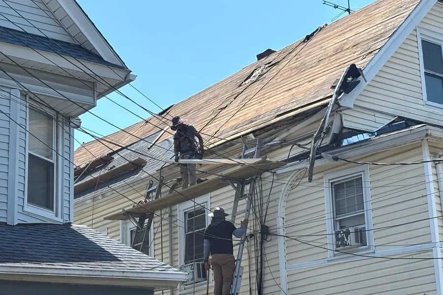 Workers using scaffolding during roof deck preparation