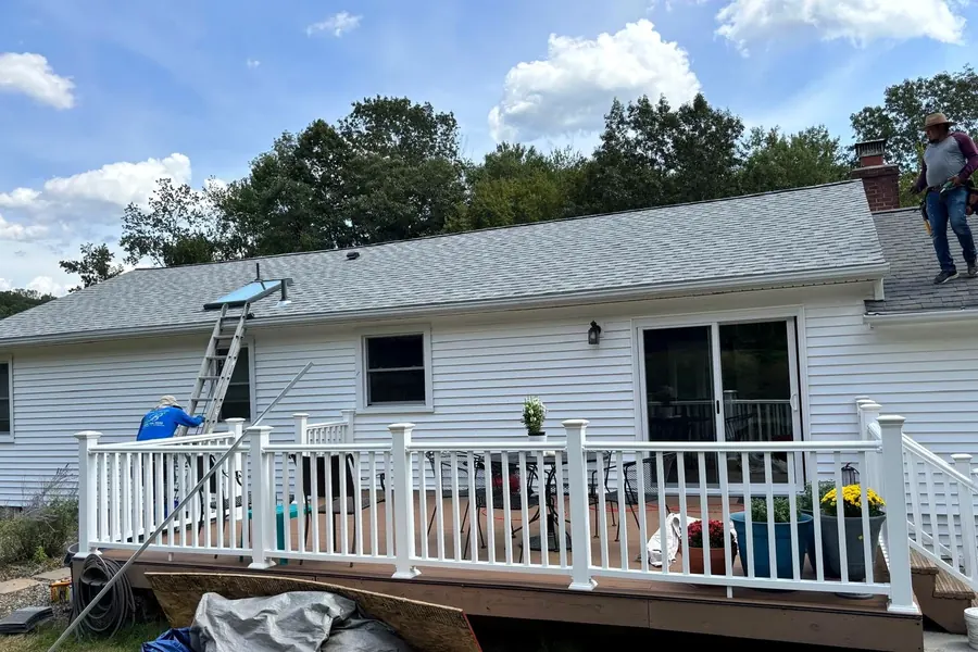 Shingled residential roof above a backyard deck