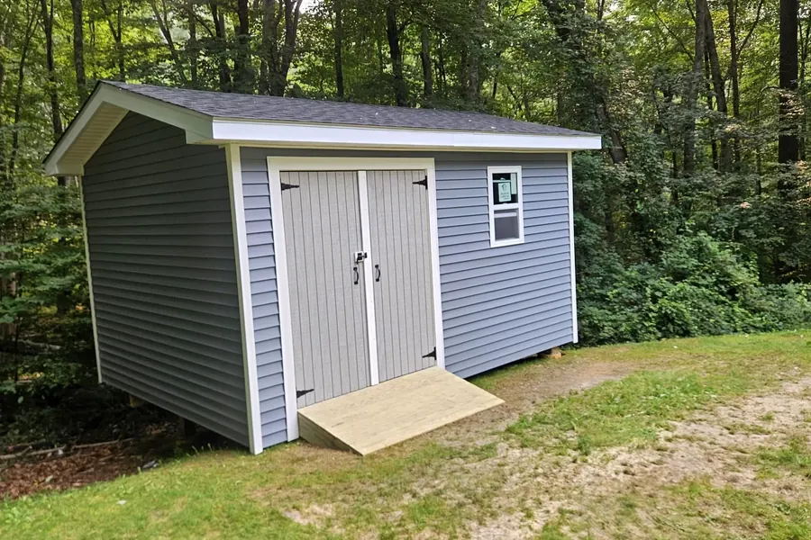 Shed exterior with shingle roof and double doors