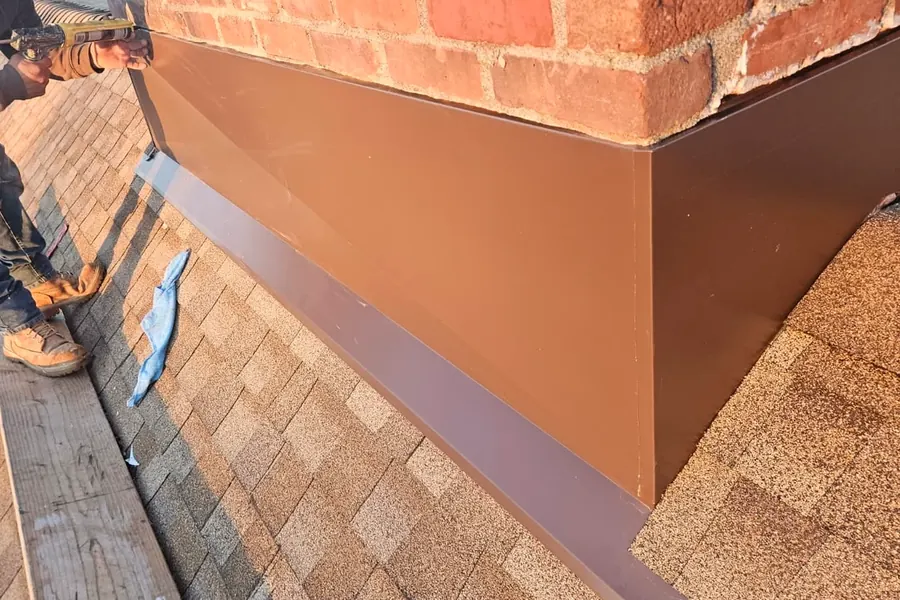 Close-up of chimney flashing work on a shingled roof